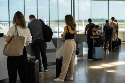 Passageiros aguardam informações sobre voos em terminal de aeroporto brasileiro.