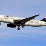Aeronave da Volaris voando sob céu azul.