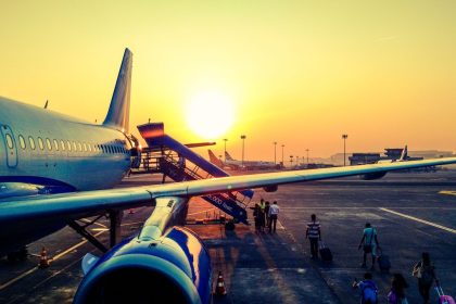 Passageiros embarcam em um avião ao amanhecer.