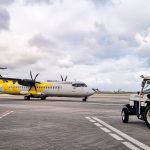 Avião turboélice na pista de um aeroporto do Rio de Janeiro, com equipe de solo ao redor.
